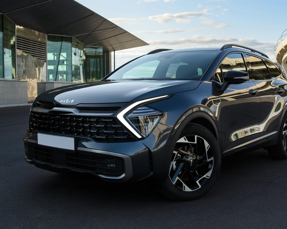 Современный внедорожник Kia Sportage, припаркованный у современного здания, олицетворяет качество и стиль, которые мы обслуживаем ежедневно.