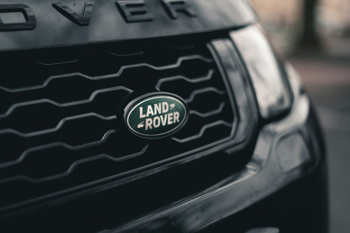Эмблема бренда Land Rover на решётке радиатора роскошного внедорожника, символизирующая наш опыт в обслуживании премиальных полноприводных и внедорожных автомобилей.