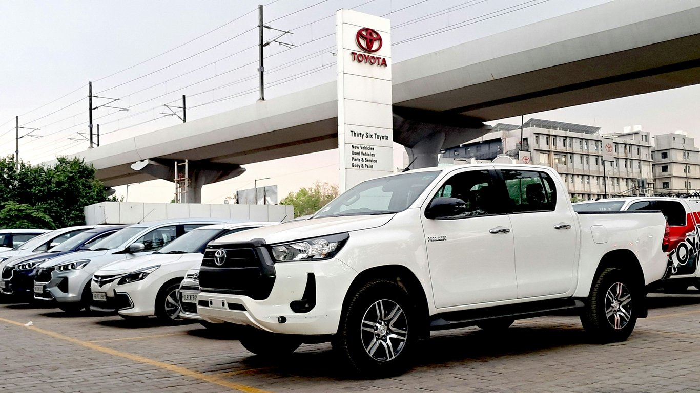 Белый пикап Toyota Hilux в дилерском центре, символизирующий надёжность, которую мы обеспечиваем благодаря нашим экспертным услугам по ремонту Toyota.