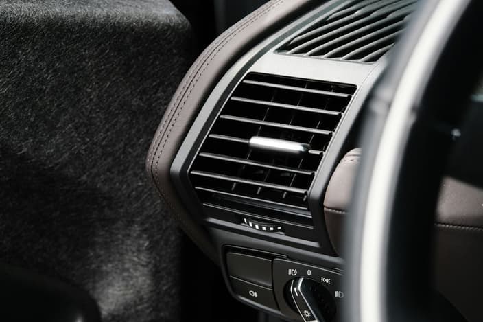 Detailní záběr na palubní desku auta s ventilačním otvorem, zvýrazňující význam kabinového filtru pro kvalitu vzduchu v interiéru.