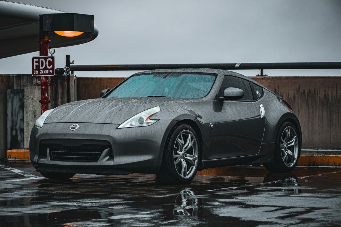 Elegantní šedé sportovní kupé Nissan 370Z, reprezentující naši odbornost v údržbě a opravách výkonných sportovních vozů.