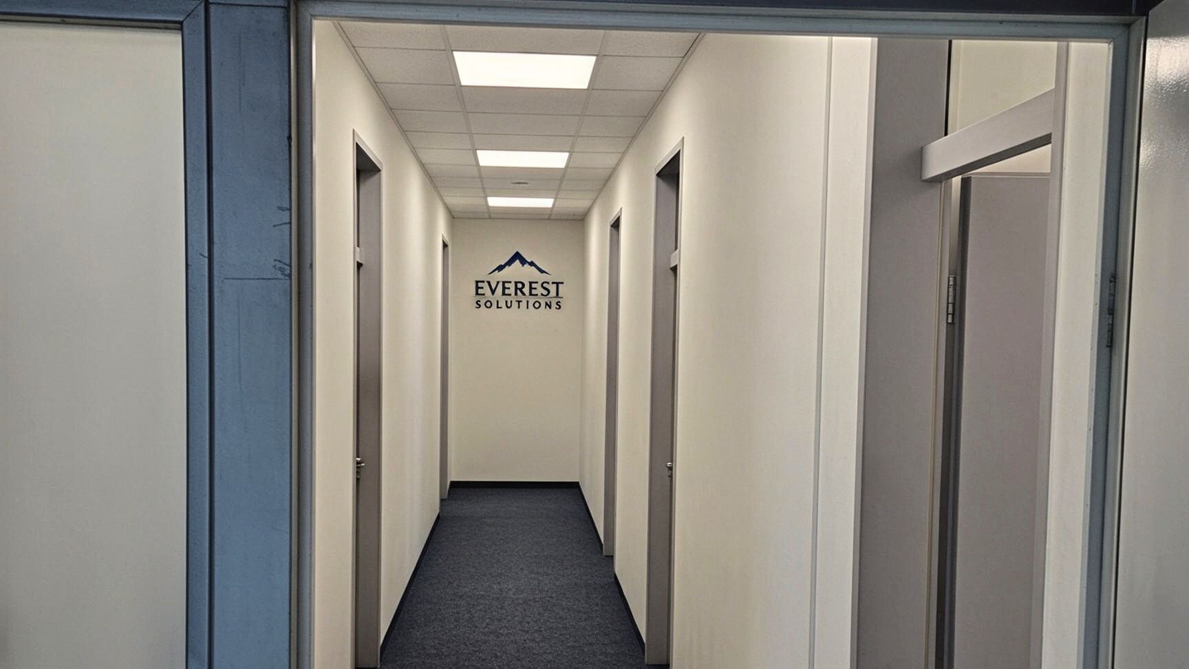 Фотография, обработанная ИИ: коридор офиса EVEREST Solutions в Праге с логотипом компании на торцевой стене