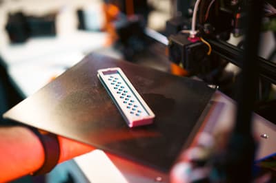 Close-up of an FDM 3D printer in operation — demonstrating additive manufacturing precision in a workshop