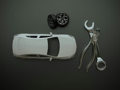 3D printed parts for the automotive industry, including covers and prototypes, lying next to a wrench.